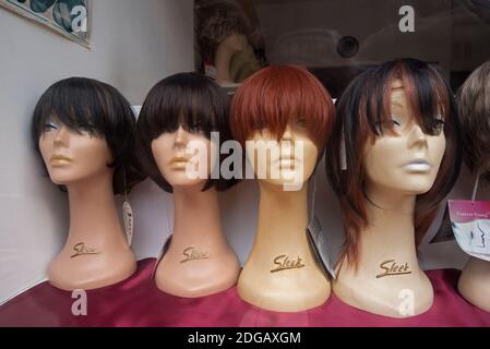 Weibliche Schaufensterpuppe Köpfe mit Perücken auf dem Display in einem Schaufenster in Edinburgh, Schottland, Großbritannien. Stockfoto