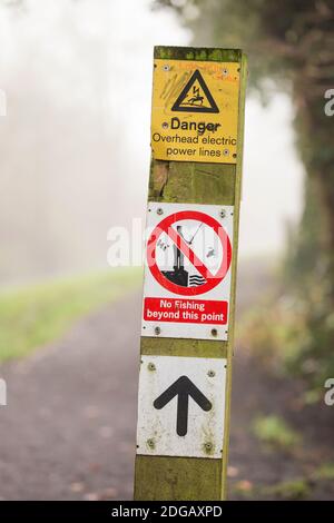 Hinweisschild, Gefahr über Stromleitungen, kein Angeln auf einem Kanalweg Stockfoto