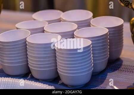 Stapel saubere weiße Schale auf einem Tisch für ein Buffet im Restaurant. Gereinigte weiße Suppe oder Salatschüsseln in der kommerziellen Küche des Restaurants. Stapel Kl Stockfoto