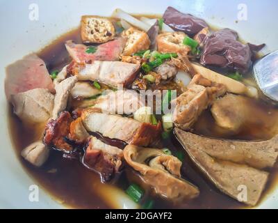 Chinesische Nudelsuppe oder Kuay Jub, eines der thailändischen Street Food, die Nudeln Rolle, Schweinefleisch Lebern, Schweineblut, Schweinenniere, gekochte Eier und Fleisch enthalten. Stockfoto