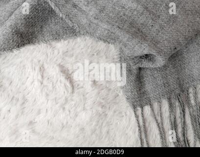 Wollschal in grauer Farbe auf weißem Hintergrund, Draufsicht, Platz für Text. Winterkleidung Stockfoto