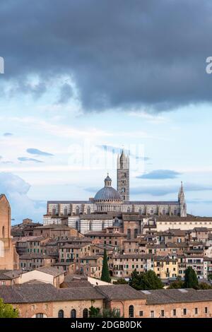 Stadtansicht des Duomo di Siena mit dunklen Wolken über der Stadt, von der Fortezza Medicea aus gesehen, Siena, Toskana, Italien Stockfoto