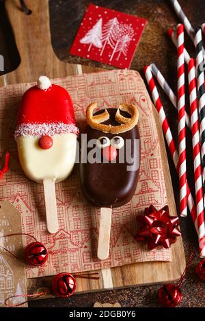 Сhocolate popsicle. Weihnachtskonzept. Schokoladeneis auf einem Stock mit einem weihnachtlichen Hirschgesicht mit einer süßen roten Nase. Weihnachtsbacken. Vorbereitungen f Stockfoto