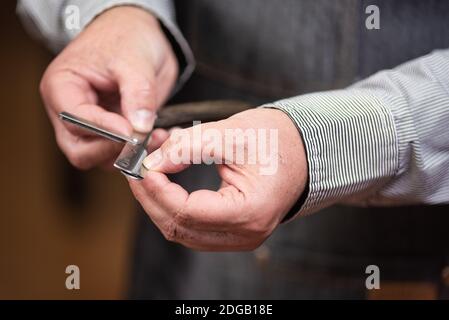 Nahaufnahme von Barbier Hände Wechsel der Rasiermesser. Friseur Frisur Serie. Stockfoto