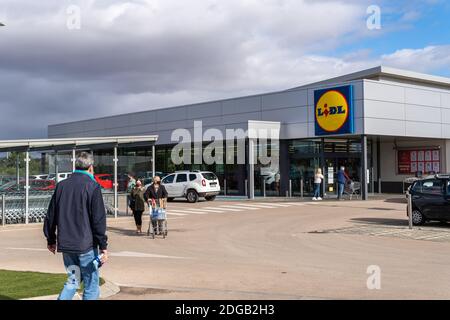 Campos, Spanien; dezember 2020: Eingang eines Supermarkts einer deutschen Lebensmittelkette. Am Eingang verlassen Kunden mit Lebensmittelwagen und Gesichtsmaske. Neu Stockfoto