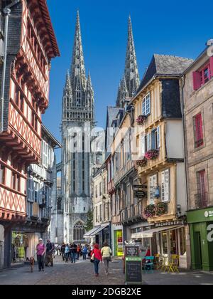 Quimper Brittany historischen Altstadt Rue Kereon QUIMPER Kathedrale Türme im Hintergrund. Besucher genießen sonnigen Spaziergang auf historischen gepflasterten Straße mit Geschäften Café und Restaurants in klaren sonnigen Bedingungen Quimper France Stockfoto