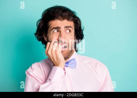 Foto Porträt des Mannes beißen Nägel suchen zur Seite isoliert Auf pastellfarbenem blauem Hintergrund Stockfoto