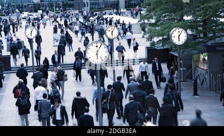 UHREN CANARY WHARF MASSEN PENDLER NACH HAUSE GEHEN BESCHÄFTIGT CANARY WHARF Uhren 18,05 Uhr Gesichter Zeit London Pendler Büroangestellte machen Täglich pendeln nach Hause am Ende des Arbeitstages South Colonnade Canary Wharf London, Großbritannien Stockfoto