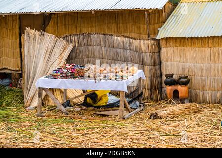 Souvenir zum Verkauf auf dem Holztisch und ein Teil Von Haus aus Totora Schilf Stockfoto