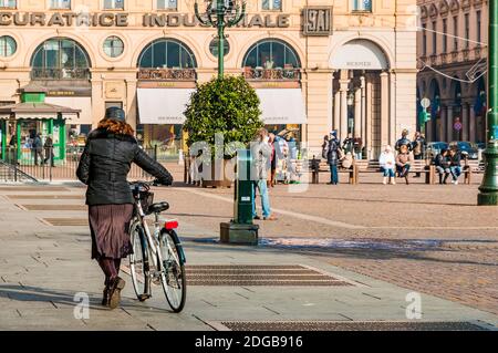 Frau mit Fahrrad. Piazza San Carlo ist einer der wichtigsten Plätze der Stadt in Turin, ist ein Beispiel für barocken Stil. Sein aktueller Name ist eine Hommage an Charl Stockfoto