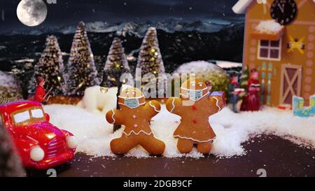 Lebkuchenkekse in Weihnachten Magisches Dorf mit schützender medizinischer Maske. Sicherheit Weihnachten Winterferien während Coronavirus Pandemie Konzept. Stockfoto