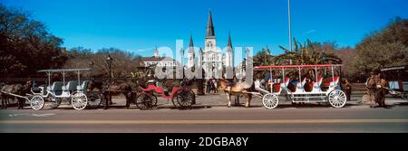 Pferdekutschen auf der Straße mit St. Louis Kathedrale im Hintergrund, Jackson Square, New Orleans, Louisiana, USA Stockfoto