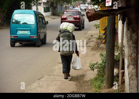 Arbeiter trägt einen Sack auf dem Kopf nach Hause. Ende des Arbeitstages, harte Arbeit auf den philippinen, asien Stockfoto