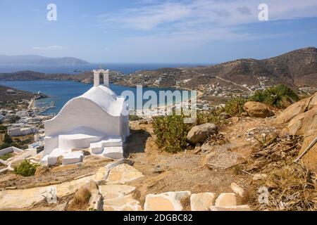 Blick auf die Insel iOS mit einer kleinen weißen Kapelle auf einem Berg im Stadtzentrum von Chora. Ios-Insel. Blick auf die Bucht und die Ägäis. Cyclade Stockfoto