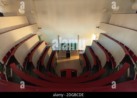 Ein leerer Saal in einer deutschen Universität. Ein Mann steht vor der Tafel und breitet seine Arme aus. Stockfoto