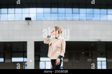 Junge schöne Geschäftsfrau mit Sonnenbrille, Telefon, Laptop, Tasse Kaffee in der Stadt Straße Stockfoto