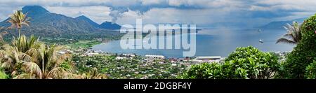 Hochwinkelansicht einer Stadt an der Küste mit Vulkan im Hintergrund, Tavurvur, Rabaul, Ostneubritannien, Papua-Neuguinea Stockfoto