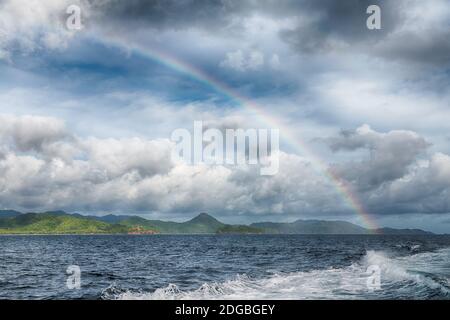 Der Regenbogen vom Ozean und Insel im Hintergrund Stockfoto