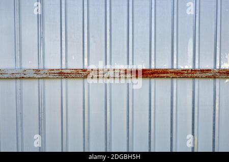 Eiserner rostiger Zaun. Weiße Wellblech oder Zink Textur Oberfläche oder galvanisieren Stahl in der vertikalen Linie Hintergrund Stockfoto