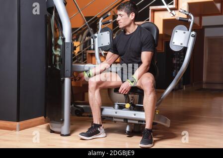 Gut aussehende muskulösen Mann bereit, zu trainieren bei Presse Brust Maschine. Brust-Workouts. Stockfoto