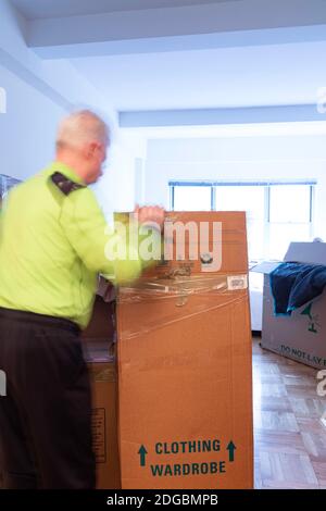 Senior Mann Auspacken in seiner neuen Wohnung in New York City, USA Stockfoto