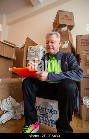 Senior Mann Auspacken in seiner neuen Wohnung in New York City, USA Stockfoto