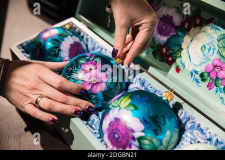 Moskau, Russland. Dezember 2020. Ein Arbeiter packt Hand-verzierte Weihnachtsschmuck in Zhostovo dekorative Malerei Fabrik, in der Region Moskau, Russland, am 8. Dezember 2020. Zhostovo ist ein russisches Volkskunstzentrum, das für seine bemalten Tabletts berühmt ist, die mit hellen Blumensträuchern verziert sind. Quelle: Maxim Chernavsky/Xinhua/Alamy Live News Stockfoto