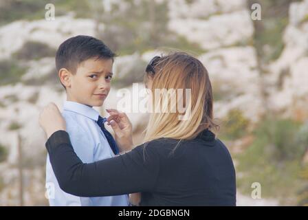 Porträt einer Mutter, die die Krawatte ihres Sohnes anpasst Stockfoto