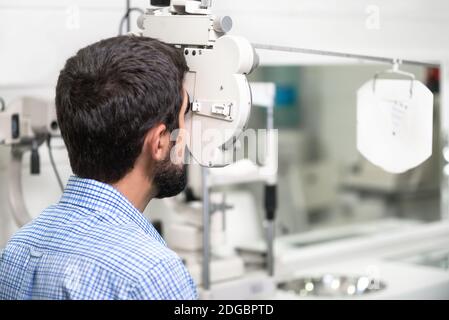 Der Patient liest die Optometristafel in der modernen Augenklinik. Stockfoto