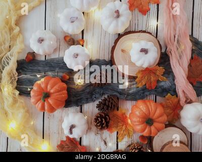 Kürbis, Tannenzapfen, Herbstblätter und Lichterkette auf einem Tisch Stockfoto