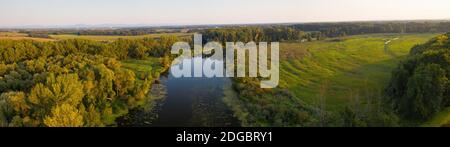 Abend Sonne wirft lange Schatten über Sommer Natur Landschaft mit Fluss und Wiesen Stockfoto