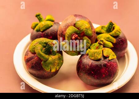 Mangostan ganze Früchte liegen auf einem weißen Teller aus nächster Nähe Dessert asien Stockfoto