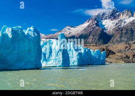 Blick auf den blauen Eisberg des Grey Glacier in Grey Lake Und schönen schneebedeckten Berg Stockfoto