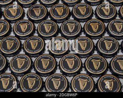 Eine Sammlung von Guinness Bierflaschen-Verschlüssen sind in einem flachen Display angeordnet, in einem Winkel in den 2020er Jahren betrachtet. Nur für redaktionelle Zwecke. Stockfoto