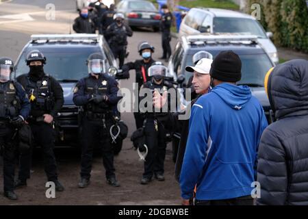 Portland, USA. Dezember 2020. Polizeibeamte treten am 8. Dezember 2020 mit Demonstranten hinter dem Roten Haus in der Mississippi Straße in Portland, Oregon, auf, als sie versuchen, das Grundstück zu vertreiben. Aktivisten zelteten seit September vor dem Haus in der Hoffnung, die dort lebende Familie der Schwarzen und Indigenen zu erhalten, nachdem ein Richter des Landkreises Multnomah die Räumung genehmigt hatte. (Foto: Alex Milan Tracy/Sipa USA) Quelle: SIPA USA/Alamy Live News Stockfoto