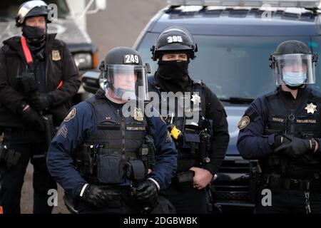 Portland, USA. Dezember 2020. Polizeibeamte treten am 8. Dezember 2020 mit Demonstranten hinter dem Roten Haus in der Mississippi Straße in Portland, Oregon, auf, als sie versuchen, das Grundstück zu vertreiben. Aktivisten zelteten seit September vor dem Haus in der Hoffnung, die dort lebende Familie der Schwarzen und Indigenen zu erhalten, nachdem ein Richter des Landkreises Multnomah die Räumung genehmigt hatte. (Foto: Alex Milan Tracy/Sipa USA) Quelle: SIPA USA/Alamy Live News Stockfoto