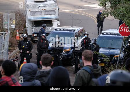 Portland, USA. Dezember 2020. Polizeibeamte treten am 8. Dezember 2020 mit Demonstranten hinter dem Roten Haus in der Mississippi Straße in Portland, Oregon, auf, als sie versuchen, das Grundstück zu vertreiben. Aktivisten zelteten seit September vor dem Haus in der Hoffnung, die dort lebende Familie der Schwarzen und Indigenen zu erhalten, nachdem ein Richter des Landkreises Multnomah die Räumung genehmigt hatte. (Foto: Alex Milan Tracy/Sipa USA) Quelle: SIPA USA/Alamy Live News Stockfoto