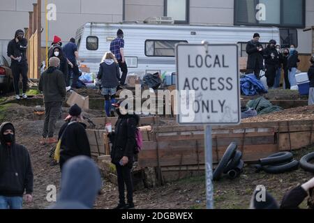 Portland, USA. Dezember 2020. Demonstranten gruppieren sich am 8. Dezember 2020 um das Rote Haus in der Mississippi Street in Portland, Oregon, herum, nachdem die Polizei es versäumt hatte, Bewohner aus dem Grundstück zu vertreiben. Aktivisten zelteten seit September vor dem Haus in der Hoffnung, die dort lebende Familie der Schwarzen und Indigenen zu erhalten, nachdem ein Richter des Landkreises Multnomah die Räumung genehmigt hatte. (Foto: Alex Milan Tracy/Sipa USA) Quelle: SIPA USA/Alamy Live News Stockfoto