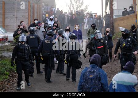 Portland, USA. Dezember 2020. Demonstranten drängen die Polizei am 8. Dezember 2020 aus dem Gebiet um das Rote Haus in der Mississippi Straße in Portland, Oregon, nach einem gescheiterten Versuch, Bewohner aus dem Grundstück zu vertreiben. Aktivisten zelteten seit September vor dem Haus in der Hoffnung, die dort lebende Familie der Schwarzen und Indigenen zu erhalten, nachdem ein Richter des Landkreises Multnomah die Räumung genehmigt hatte. (Foto: Alex Milan Tracy/Sipa USA) Quelle: SIPA USA/Alamy Live News Stockfoto