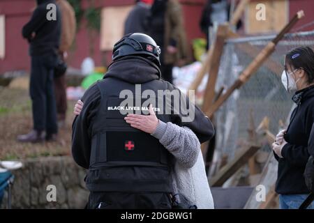 Portland, USA. Dezember 2020. Die Menschen umarmen sich, nachdem Aktivisten am 8. Dezember 2020 erfolgreich eine Polizeirazzia und Vertreibung des Roten Hauses in der Mississippi Street in Portland, Oregon, vereitelt hatten. Aktivisten zelteten seit September vor dem Haus in der Hoffnung, die dort lebende Familie der Schwarzen und Indigenen zu erhalten, nachdem ein Richter des Landkreises Multnomah die Räumung genehmigt hatte. (Foto: Alex Milan Tracy/Sipa USA) Quelle: SIPA USA/Alamy Live News Stockfoto