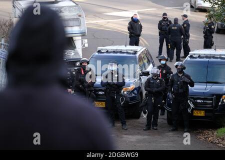 Portland, USA. Dezember 2020. Polizeibeamte treten am 8. Dezember 2020 mit Demonstranten hinter dem Roten Haus in der Mississippi Straße in Portland, Oregon, auf, als sie versuchen, das Grundstück zu vertreiben. Aktivisten zelteten seit September vor dem Haus in der Hoffnung, die dort lebende Familie der Schwarzen und Indigenen zu erhalten, nachdem ein Richter des Landkreises Multnomah die Räumung genehmigt hatte. (Foto: Alex Milan Tracy/Sipa USA) Quelle: SIPA USA/Alamy Live News Stockfoto