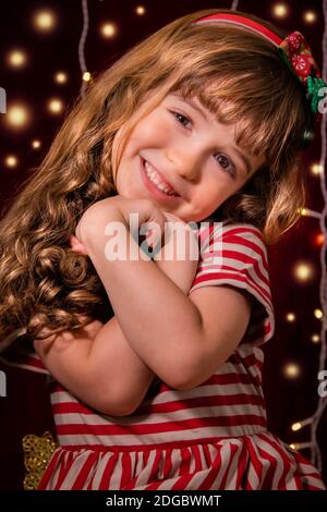 Porträt eines lächelnden Mädchens vor Weihnachtslichtern Stockfoto