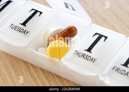 Ein Medikament in einer Kunststoffbox mit Beschreibungen zu jedem Tag des Gebrauchs, Nahaufnahme. Eine offene Pillbox mit Tablets für jeden Tag, Makroansicht. Stockfoto