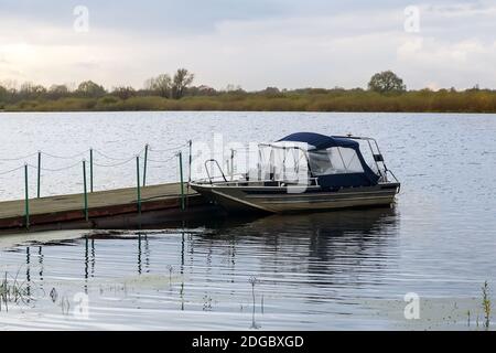 Kleines Boot am Pier auf dem Fluss. Stockfoto