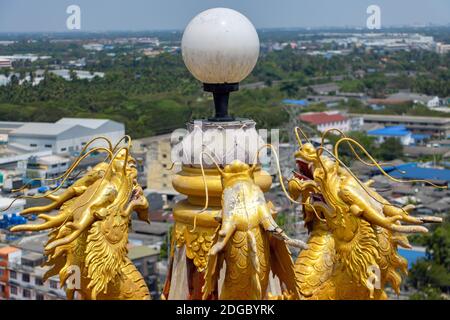 Goldene chinesische Drachenstatuen schmücken die Lampe auf dem Dach, Wat Samphran Dragon Temple, Nakhon Pathom, Thailand. Stockfoto