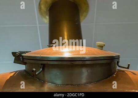 Kupferluke auf einem großen Tank auf dem Hintergrund von Ein Rohr, das die weiße Decke verlässt Stockfoto