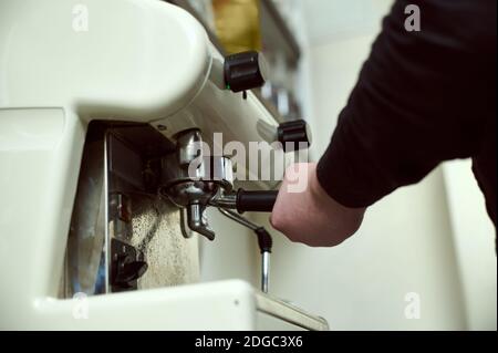 Teilansicht der Hand des Baristas, der einen Portafilter mit Grinded hält Kaffee Stockfoto