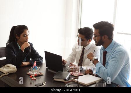 Junge und energische Untergebene diskutieren im indischen Büro mit weiblicher Chefin. Indisches Unternehmen Stockfoto