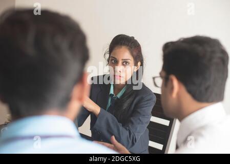 Junge und energische Untergebene diskutieren im indischen Büro mit weiblicher Chefin. Indisches Unternehmen Stockfoto