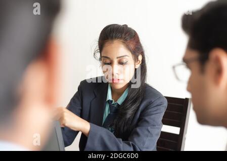 Junge und energische Untergebene diskutieren im indischen Büro mit weiblicher Chefin. Indisches Unternehmen Stockfoto